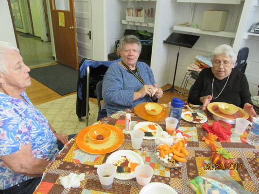women make fall flowers at a table