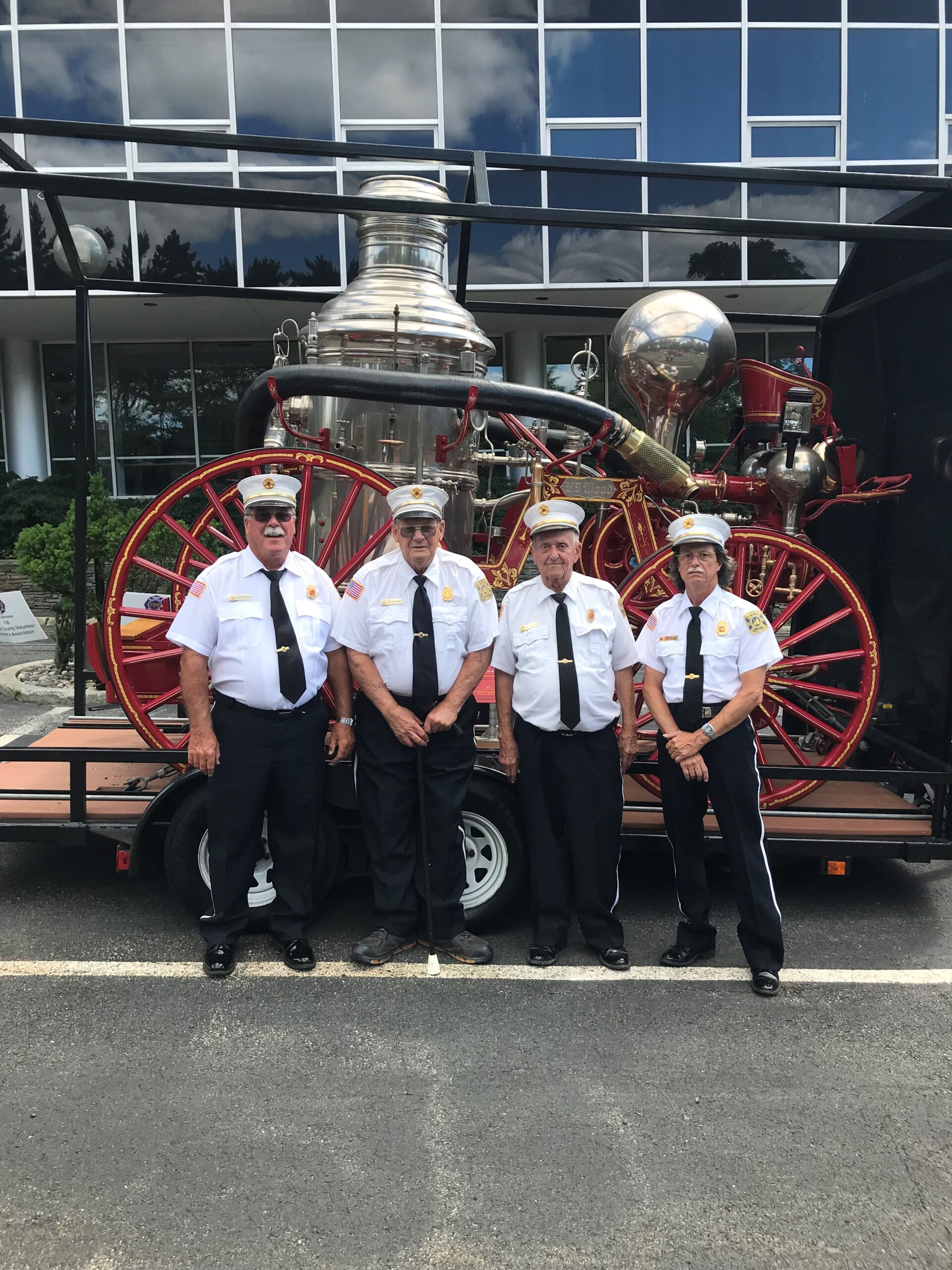firefighters stand in front of antique fire engine