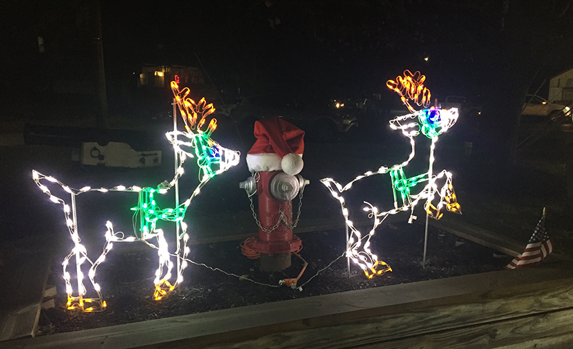 reindeer ornaments lit up near fire hydrant
