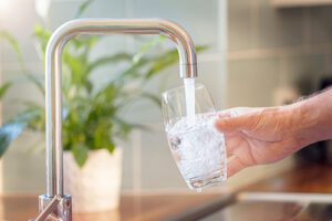 filling a glass of water out of a kitchen facet
